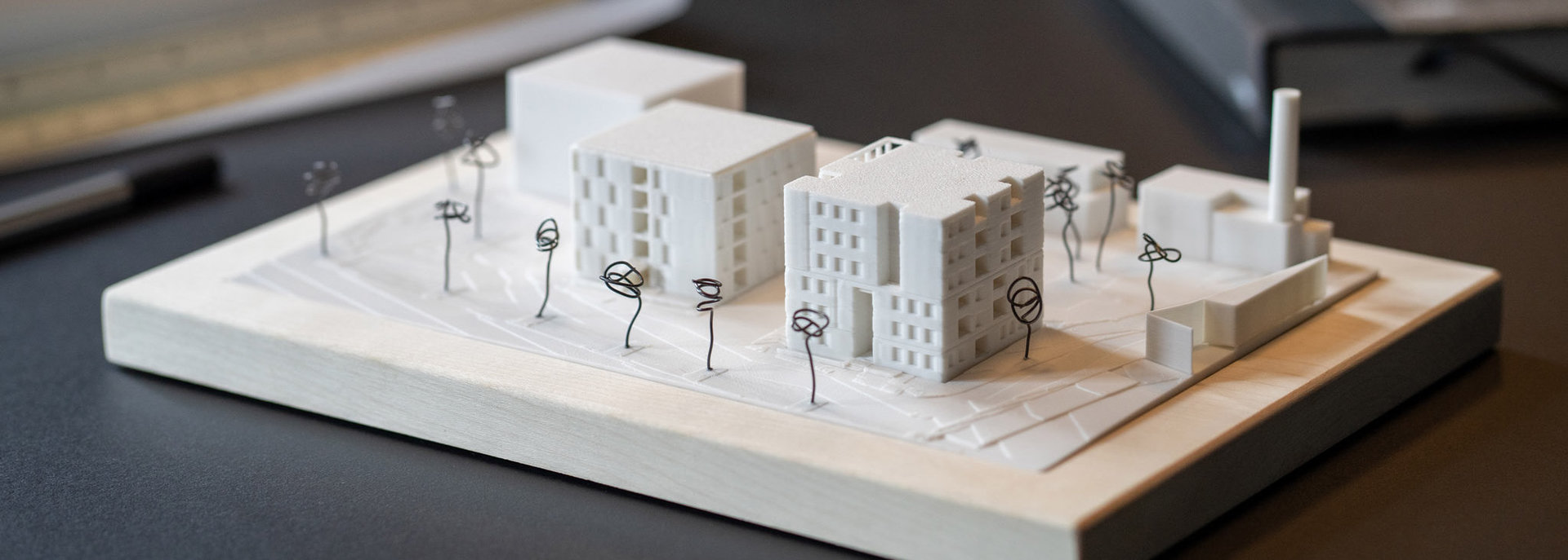 Detailaufnahme eines 3D-gedruckten Städtebaumodells mit Gebäuden und abstrahierten Bäumen